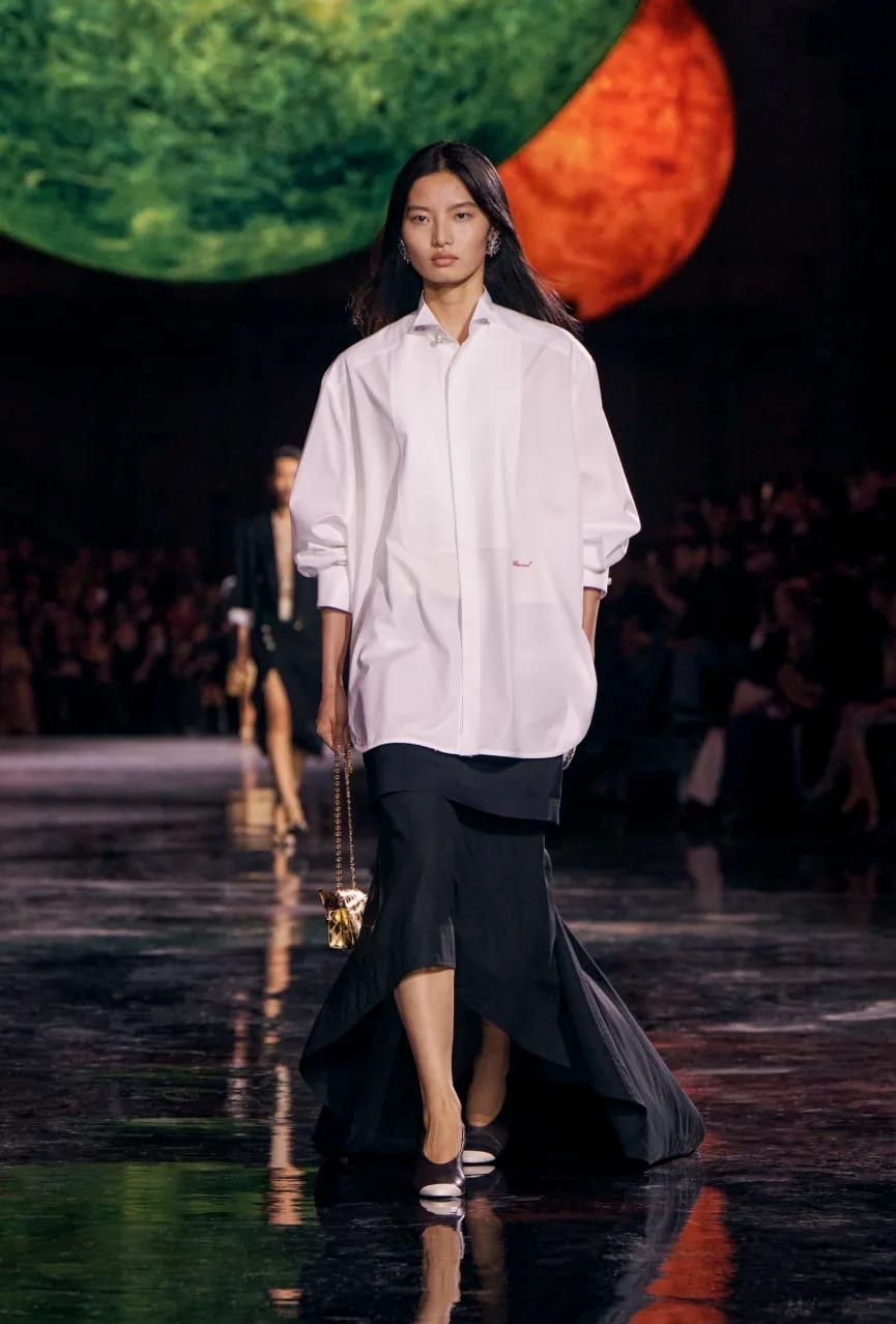 Look 13 in Matthieu Blazy's debut show for Chanel features a crisp white button-up and a voluminous skirt